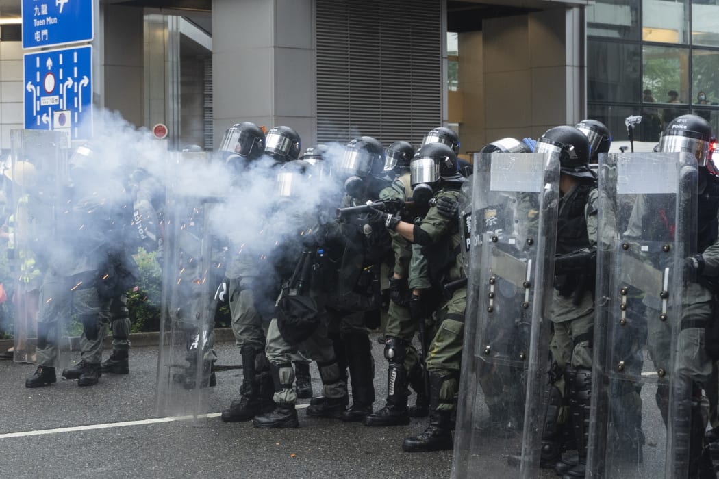 Riot police fire tear gas to disperse anti-government protesters outside a shopping mall which is surrounded by residential buildings in Tsuen Wan, Hong Kong.