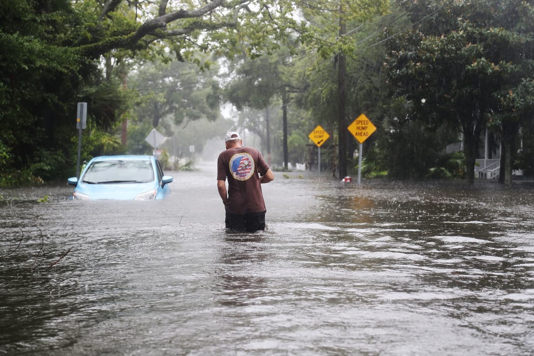 A man walks through a flooded street as Hurricane Matthew passes through St Augustine, Florida