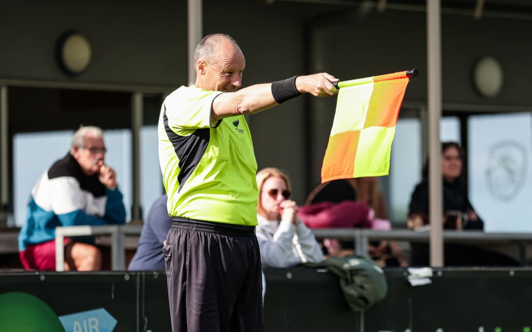 Asisten wasit menandakan offside.