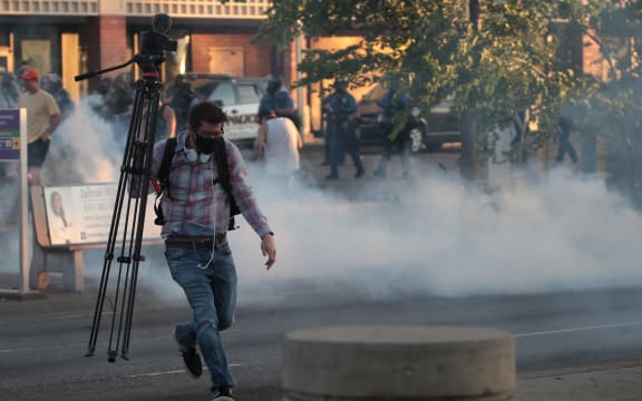 A member of the media runs through tear gas during a protest on May 28, 2020 in St. Paul, Minnesota.