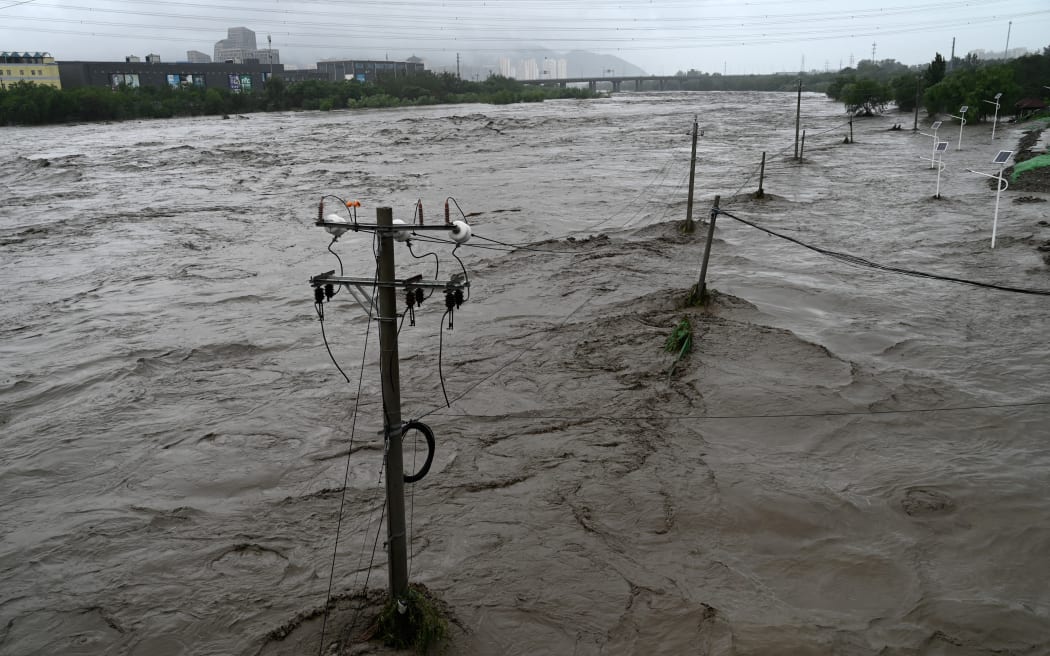 The Yongding River overflows after heavy rain in Mentougou district in Beijing on 31 July 2023.