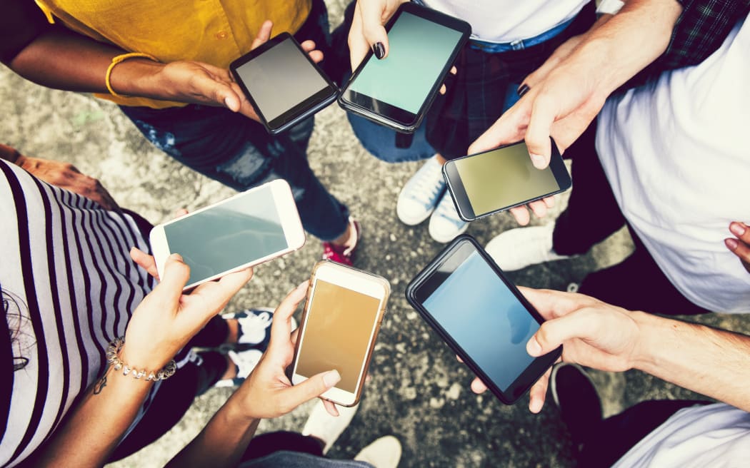 Diverse friends using their phones.