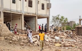 People inspect the rubble at a house that was hit by an artillery shell in the Azhari district in the south of Khartoum on June 6, 2023. The United States and Saudi Arabia on June 4 made a renewed push for truce talks between Sudan's warring generals as deadly fighting has raged into its eighth week. Multiple ceasefires have been agreed and broken, and Washington slapped sanctions on the two warring generals last week, blaming both sides for the "appalling" bloodshed. (Photo by AFP)