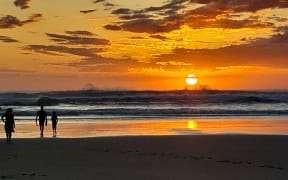 Holidaymakers enjoy Northland's west coast sunset yesterday evening at Baylys Beach, 13km west of Dargaville, after temperatures reached 25C during the day.