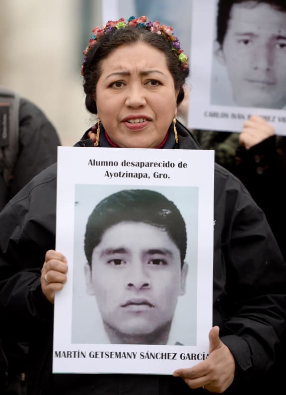 A supporter of the human rights organisation Amnesty International holds a photo of Martin Getsemany Sanchez Garcia, one of 43 missing Mexican students.