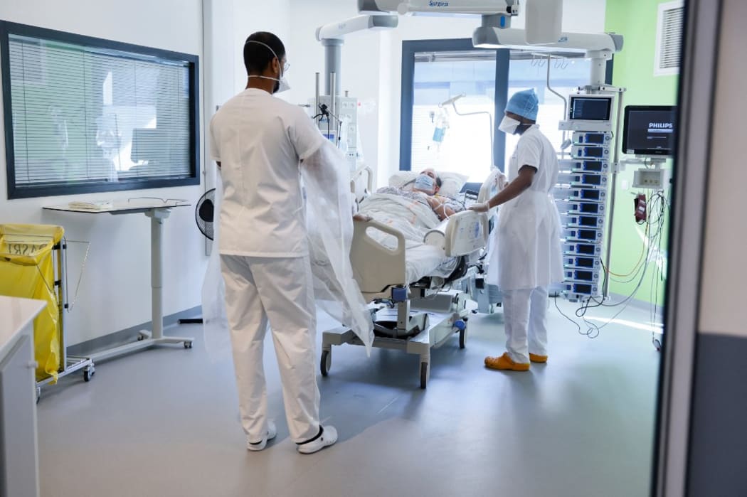 A patient infected with the COVID-19 (coronavirus) is carried by stretcher bearers in the intensive care unit of the Delafontaine Hospital in Saint-Denis, northern suburb of Paris, on March 29, 2021.