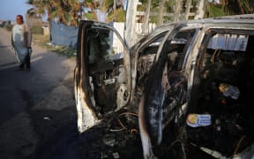 Palestinians are standing next to a vehicle in Deir Al-Balah, in the central Gaza Strip, on April 2, 2024, where employees from the World Central Kitchen (WCK), including foreigners, were killed in an Israeli airstrike, according to the NGO. The Israeli military is stating that it is conducting a thorough review at the highest levels to understand the circumstances of this ''tragic'' incident, amid the ongoing conflict between Israel and Hamas. (Photo by Majdi Fathi/NurPhoto) (Photo by MAJDI FATHI / NurPhoto / NurPhoto via AFP)