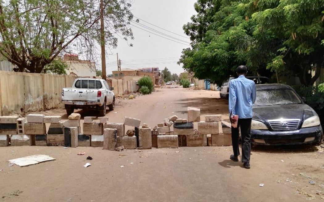 A Sudanese man walks towards a barricade made of bricks to block a street for cars in Khartoum's twin city Omdurman on the first day of a civil disobedience campaign across Sudan on June 9, 2019. )