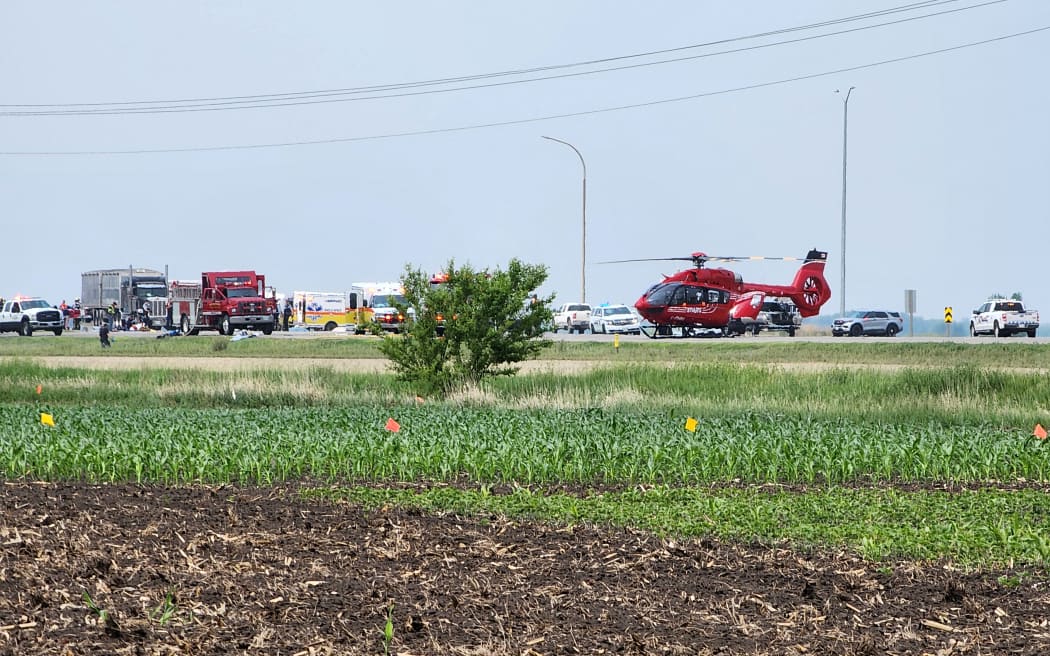 Smoke comes out of a car as first responders are pictured following a road accident that left 15 dead near Carberry, west of Winnipeg, Canada on June 15, 2023. At least 15 people died June 15, 2023 in a road accident in central Canada's Manitoba province, local media reported. Canadian police said on Twitter that officers were responding to a "mass casualty collision" near the town of Carberry, west of Winnipeg, and that first responders and other Royal Canadian Mounted Police units were on the scene. (Photo by Nirmesh VADERA / AFP)