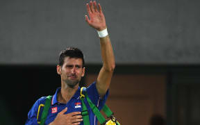 Serbia's Novak Djokovic waves to the crowd with tears in his eyes after losing his men's first round singles tennis match against Argentina's Juan Martin Del Potro at the Olympic Tennis Centre of the Rio 2016 Olympic Games in Rio de Janeiro on August 7, 2016.