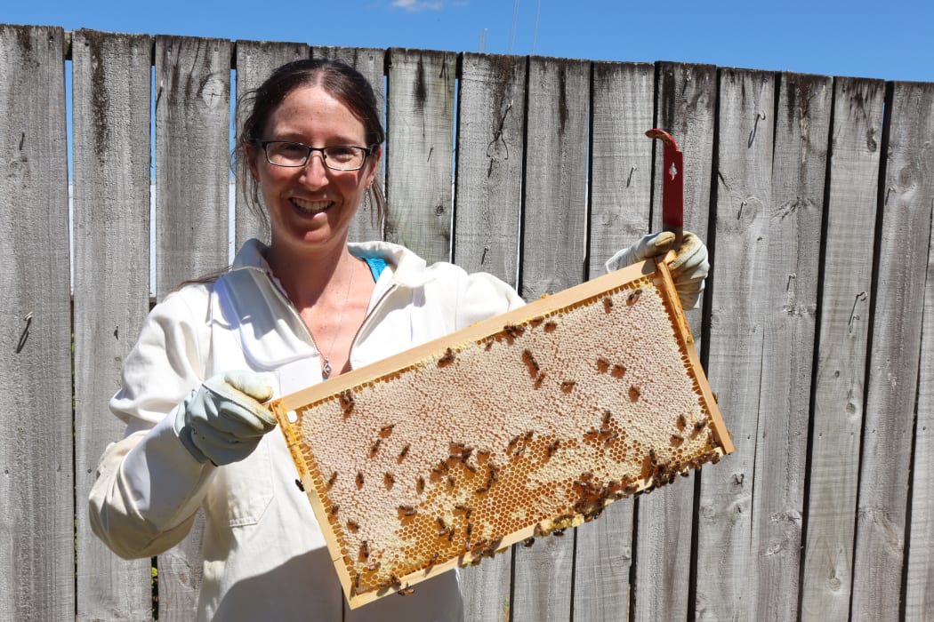 Dr. Megan Grainger tends her bees at home.