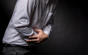 A man clutching his stomach.