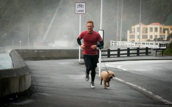 A keen Wellingtonian battling the wild winds that are pounding Evans Bay.