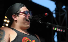 Rome Ramirez of Sublime with Rome, singing into a microphone, at the Tortuga Music Festival