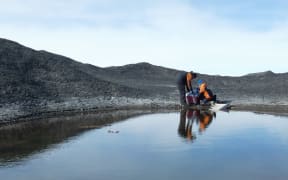 Researchers taking samples at the meltwater ponds in Antarctica.