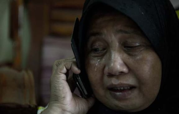 A relative of Malaysia Airlines passengers Norliakmar Hamid and Razahan Zamani, cries at their home.