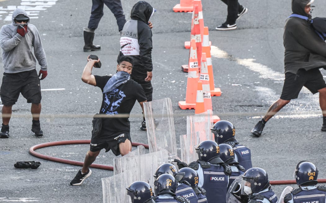 A paving stone is thrown at police on the Bowen/Lambton corner