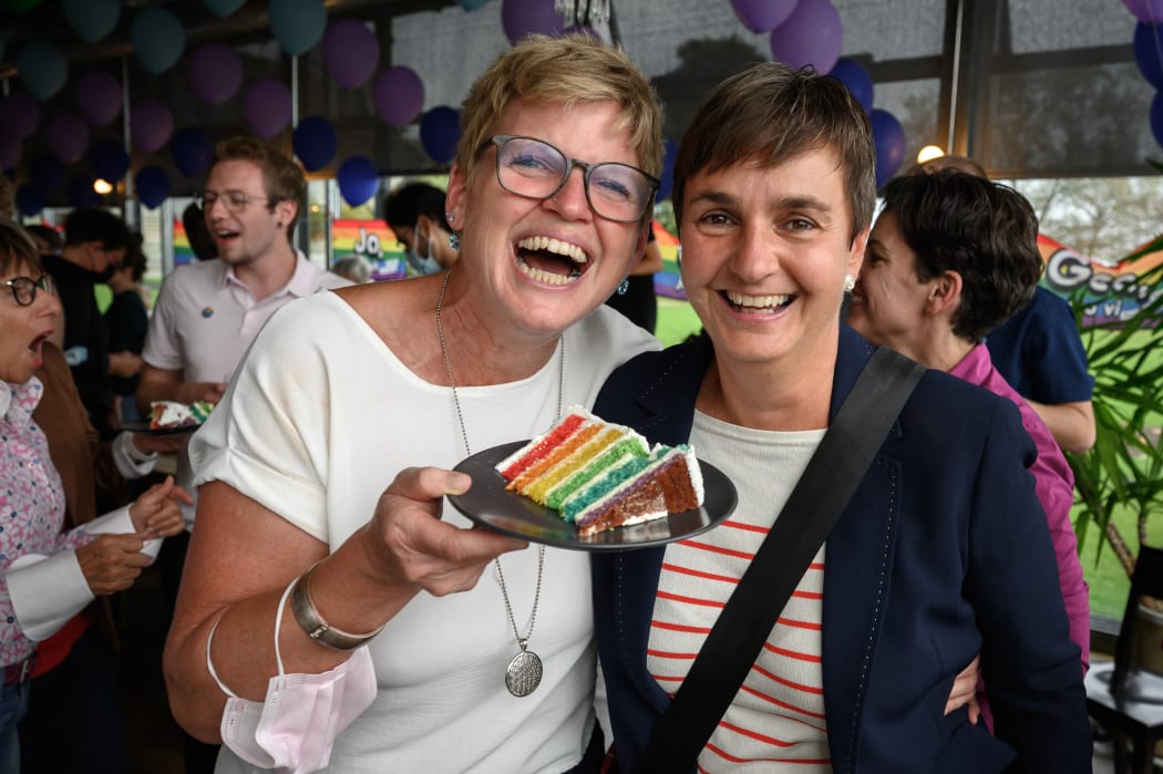 A couple poses with a wedding cake's slice during an event following a nationwide referendum on same-sex marriage, in Swiss capital Bern on September 26, 2021.