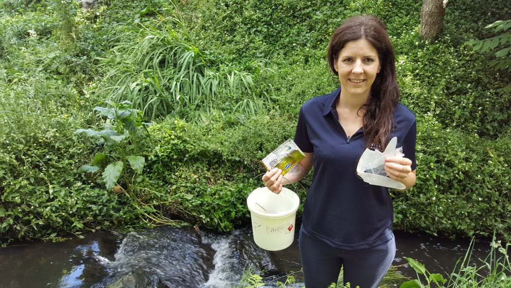 Amanda Valois in Hamilton's Donny Park holding mostly plastic rubbish she picked up along the 100 metre walk from the road to the stream.