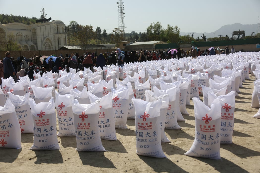 People wait to receive food aid from China in Kabul, Afghanistan, on April 7, 2022.