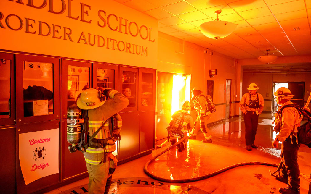 Firefighters prepare to fight flames from inside Eliot Arts Magnet Middle School auditorium as the school burns during the Eaton fire in the Altadena area of Los Angeles county, California on January 8, 2025. - At least five people are now known to have died in wildfires raging around Los Angeles, with more deaths feared, law enforcement said January 8, as terrifying blazes leveled whole streets, torching cars and houses in minutes.
More than 1,000 buildings have burned in multiple wildfires that have erupted around America's second biggest city, forcing tens of thousands of people from their homes. (Photo by JOSH EDELSON / AFP)