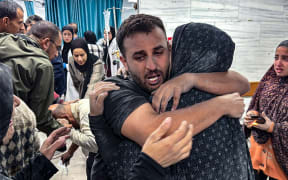 EDITORS NOTE: Graphic content / People comfort each other inside the Kamal Adwan hospital, as victims receive medical care following an Israeli strike that hit an area near the medical establishment in Beit Layia in the northern Gaza Strip early on November 21, 2024, reportedly leaving dozens of people killed or unaccounted for. (Photo by AFP)