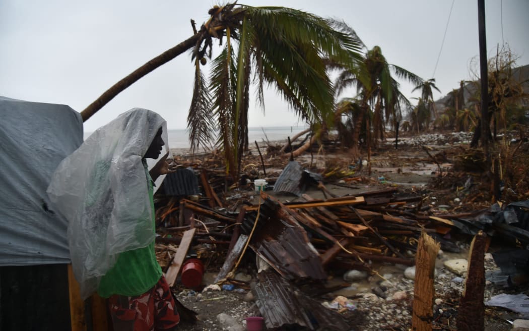 Hurricane Matthew victim James stands under the rain in front of his destroyed house in Port-a-Pimet, Les Cayes.