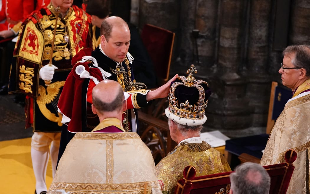 Britain's Prince William, Prince of Wales touches St Edward's Crown on the head of his father, Britain's King Charles III, during the King's Coronation Ceremony inside Westminster Abbey in central London on May 6, 2023. - The set-piece coronation is the first in Britain in 70 years, and only the second in history to be televised. Charles will be the 40th reigning monarch to be crowned at the central London church since King William I in 1066. Outside the UK, he is also king of 14 other Commonwealth countries, including Australia, Canada and New Zealand. Camilla, his second wife, will be crowned queen alongside him and be known as Queen Camilla after the ceremony. (Photo by Yui Mok / POOL / AFP)