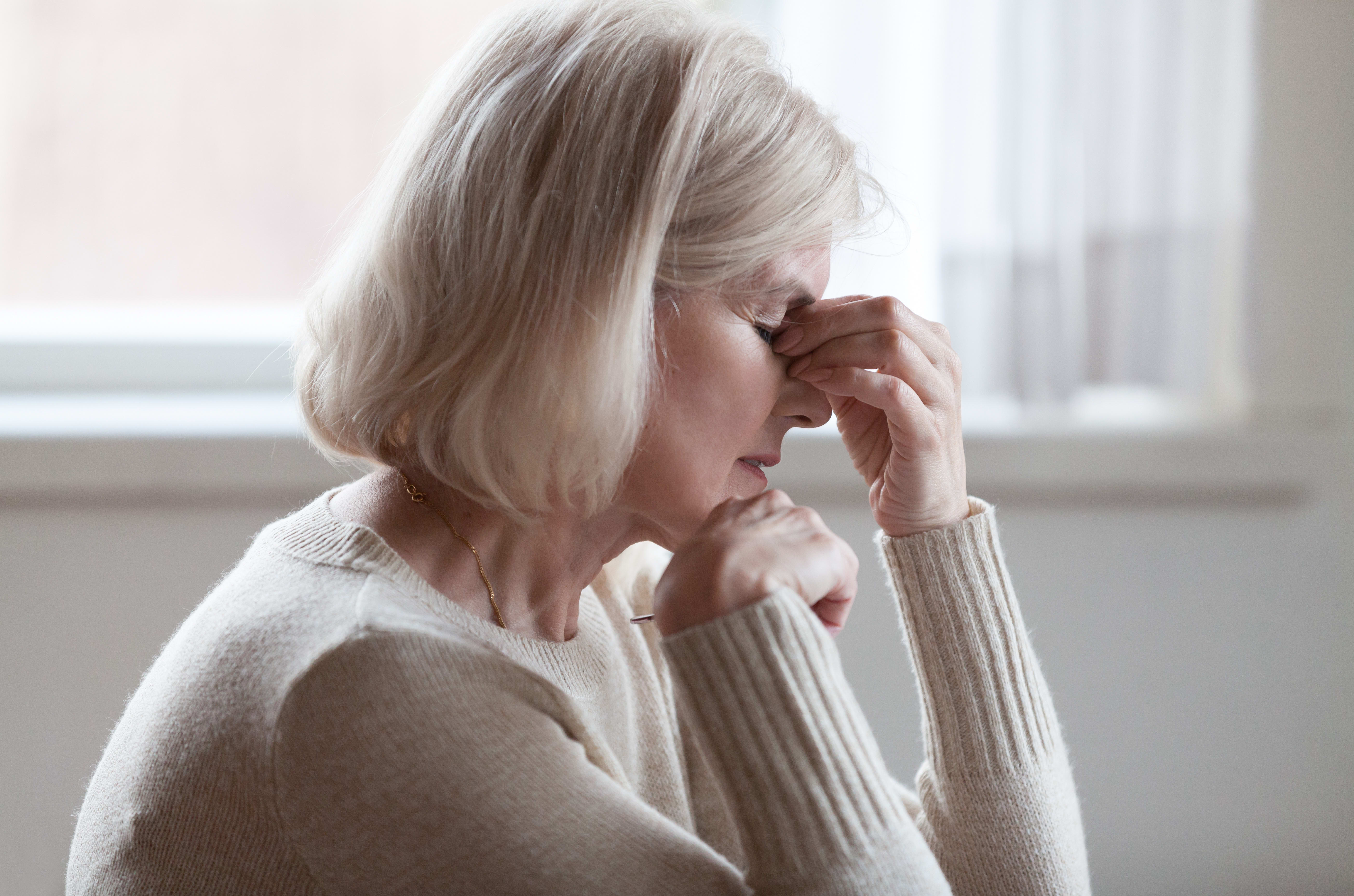 Fatigued older woman, headache, thinking, stress. (File photo)