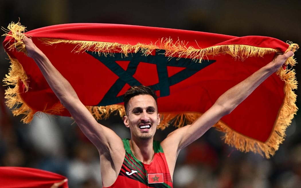 Morocco's Soufiane El Bakkali celebrates after winning the men's 3000m steeplechase final of the athletics event at the Paris 2024 Olympic Games at Stade de France in Saint-Denis, north of Paris, on August 7, 2024. (Photo by Jewel SAMAD / AFP)