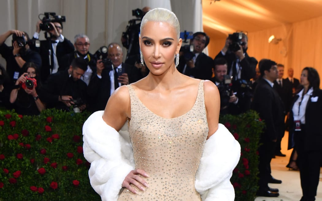 Kim Kardashian poses with Marilyn Monroe's iconic beige dress with crystals at the 2022 Met Gala.
