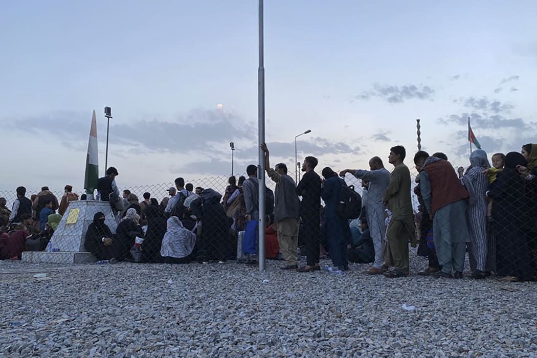 Afghan people queue up to board a US military aircraft at the military airport in Kabul, to leave the country on 19  August 2021.