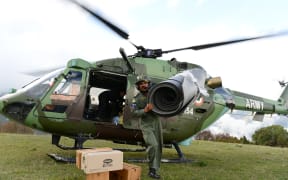 An Indian Air Force (IAF) helicopter pilot unloads relief aid in the village of Laprak.