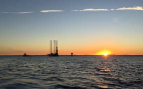 Pohokura rig in the distance with the sun just rising over the sea