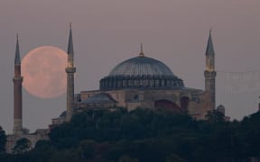 A long lens image of a sturgeon super moon rising over the Istanbul's Blue Mosque, in Turkey, on 2 August, 2023.