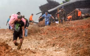 Residents evacuate their homes as rescue workers search for survivors at the site of a landslide triggered by heavy rain in Sukabumi, West Java province on January 1, 2019.