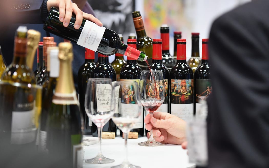 An exhibitor pours red wine during the Vinexpo at Javits Center on March 2, 2020 in New York City. The wine business dodged a bullet last month when the Trump administration held off on draconian European wine tariffs, but at a New York trade fair, the industry was not exactly celebrating. The spreading coronavirus joined the fog of US commerce policy, the murkiness of the British market post-Brexit and a glut of California wine among the leading buzz-kills at the Vinexpo. (Photo by Angela Weiss / AFP)