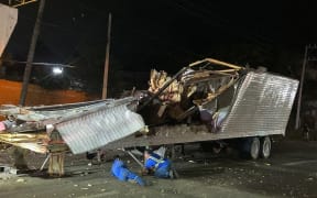 Workers remove the container from the trailer of a truck that crashed with migrants aboard during a road accident in Tuxtla Gutierrez, Chiapas state, Mexico