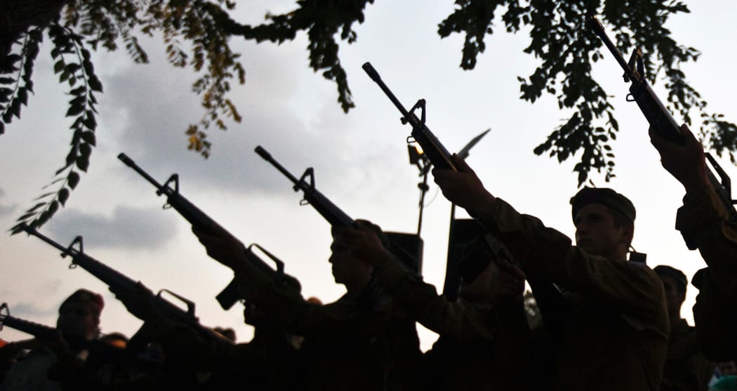 Israeli soldiers fire their weapons during the funeral of a fellow soldier in Holon.
