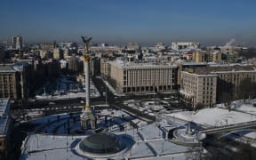 Cars drive along Independence Square during an air raid alert in Kyiv on January 20, 2026, amid the Russian invasion of Ukraine. An overnight Russian aerial attack left thousands of residential buildings in Kyiv without heating and water in -14C temperatures on January 20, 2026 -- another blow to a capital already reeling from strikes that have knocked out vital utilities. (Photo by Sergei GAPON / AFP)