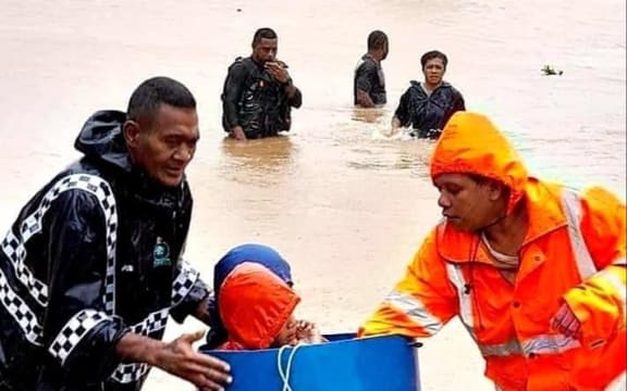 People are helped to get to safety by local police