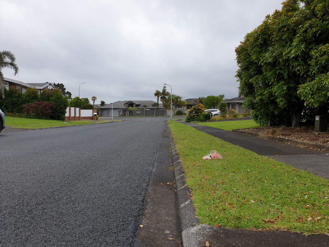 Flowers have been placed on the grass on Roadley Avenue where the car was parked