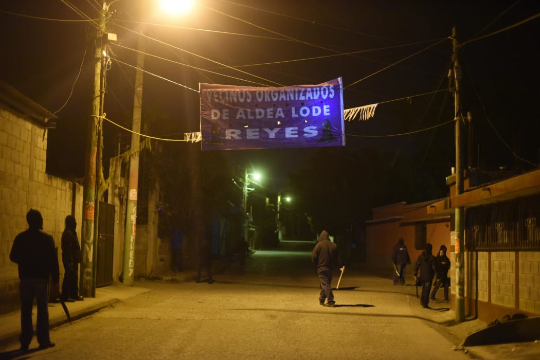 Hooded men carrying guns patrol the streets of the "Lo de Reyes" village north of Guatemala City, to prevent attacks from gang members. The country suffers rampant violence, with about 6000 murders a year.