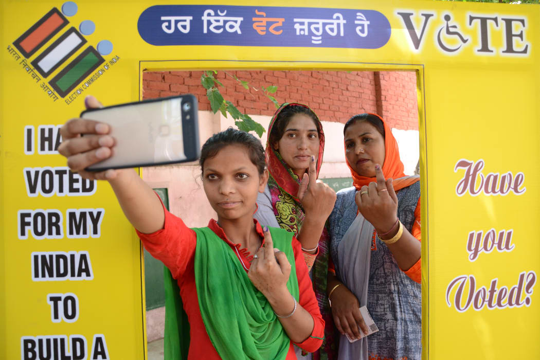 Indian voters pose for a picture with their ink-marked fingers after casting votes at a polling centre on the outskirts of Amritsar.