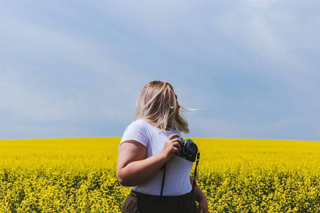 blonde woman with camera in field