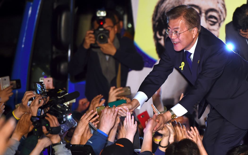 South Korean presidential candidate Moon Jae-in (R) of the Democratic Party greets his supporters as they gather to watch broadcast of the presidential election results
