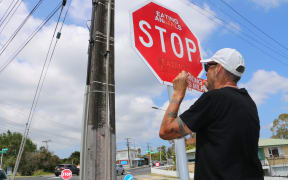Vegan activist Deno Stock replaces an old sticker that's been painted over with a fresh one.