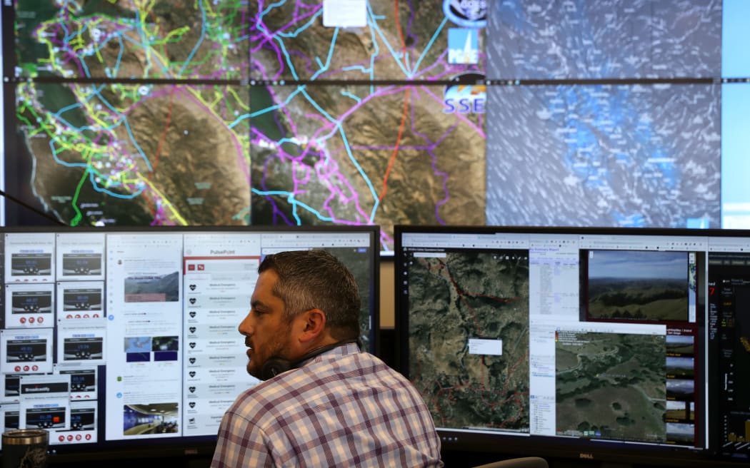 SAN FRANCISCO, CALIFORNIA - AUGUST 05: Pacific Gas and Electric (PG&E) Senior Wildfire Operations Center Analyst Anthony Malnati sits in front of video screens and computer monitors at he PG&E Wildfire Safety Operations Center on August 05, 2019 in San Francisco, California.