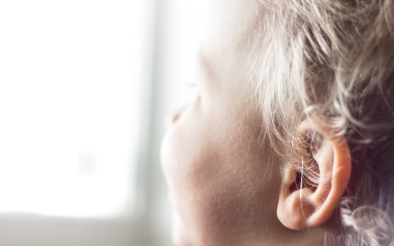 A young child looks out a window
