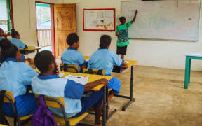 A school teacher teaching students in a classroom. 3 September 2025.